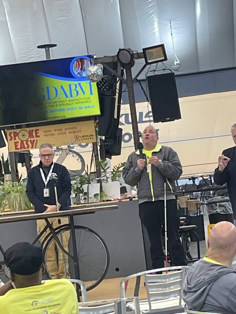 Multiple people on stage while Justice Richard Bernstein is speaking at the GDABIV 5K Walk.
